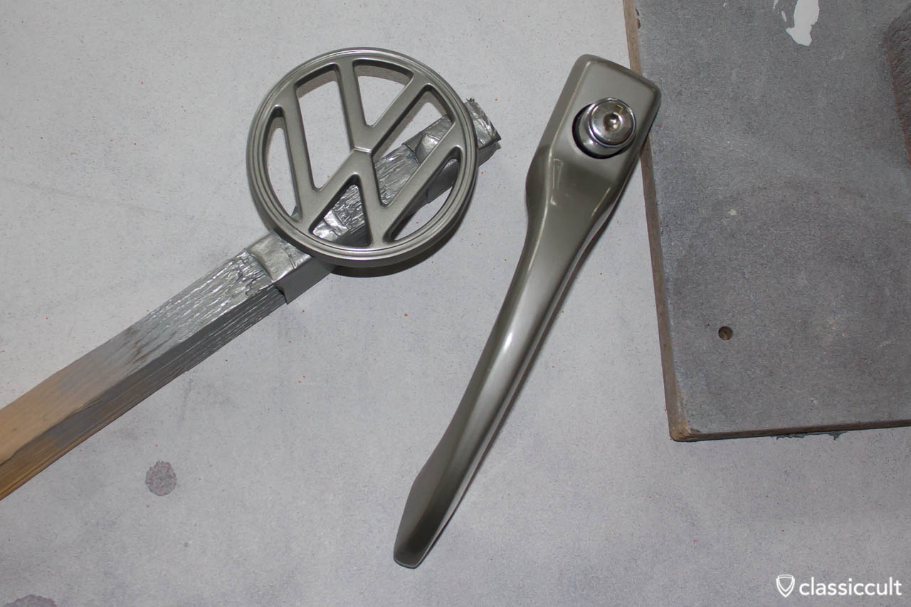 VW Beetle 1200A Hood Emblem Badge painted in L328 Standox steel grey, compared to a nos vw steel grey door handle