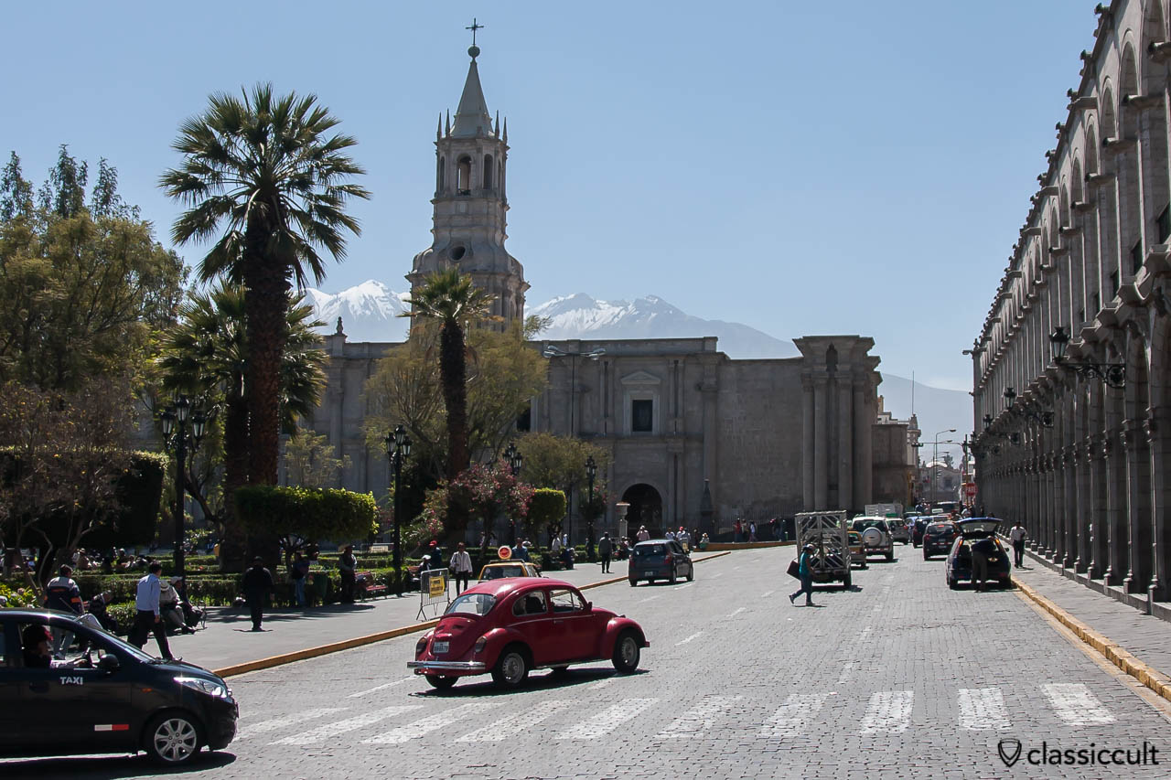 VW Bug with the Basilica Catedral of Arequipa and snow-capped mountains, Peru, May 8, 2013 